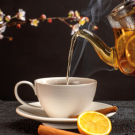 A teapot pouring liquid into a cup.